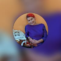 Person in purple attire smiling indoors